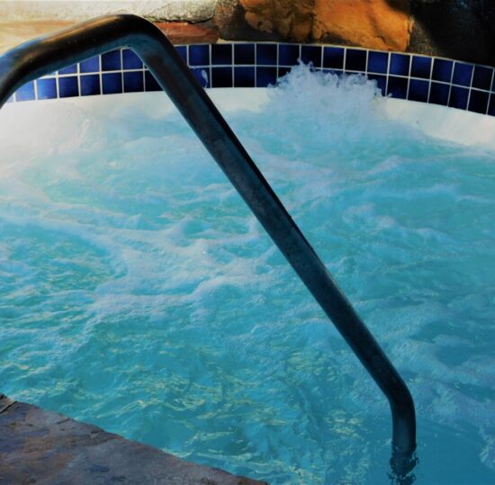 Backyard Living! An inground hot tub with swirling water from jets!