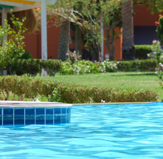 Blue clear water with small ripple waves in swimming pool at tropical resort. Summer vacations